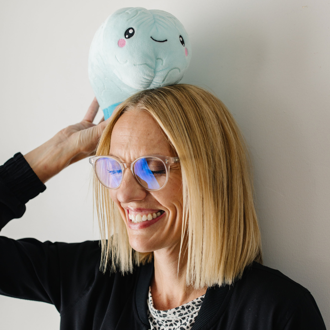 woman holding a nerdbugs brain plushie on the top of her head