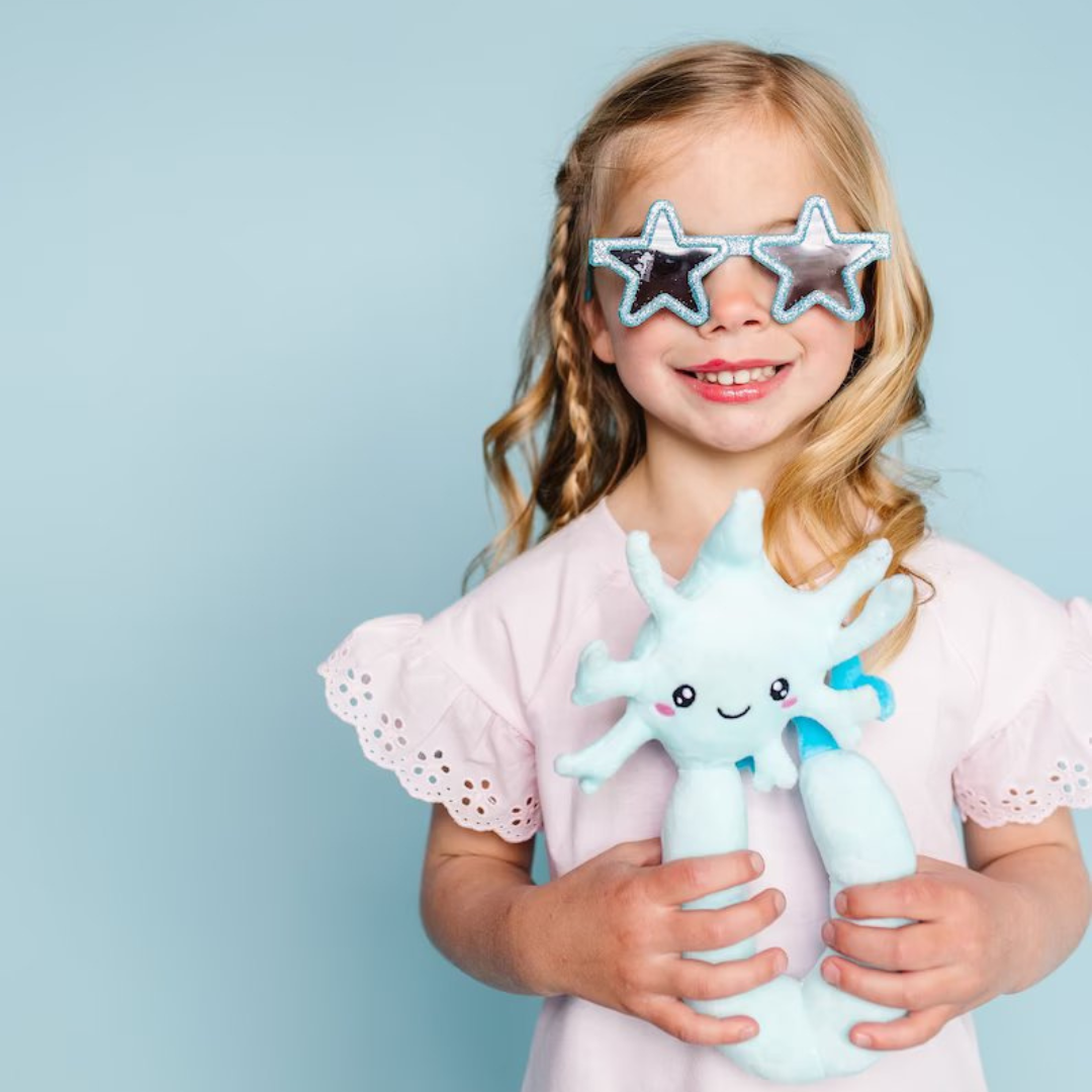 little girl wearing star-shaped glasses holding a nerdbugs neuron plushie