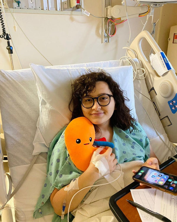 Lady on a hospital bed holding a Nerdbugs Kidney Plushie Organ