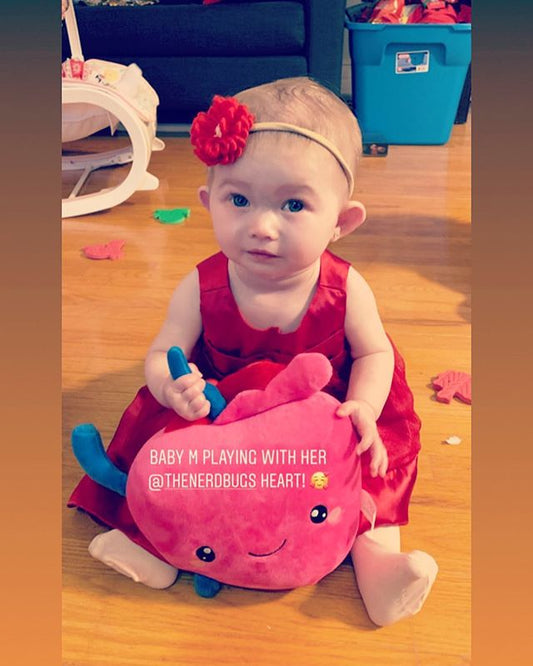 Toddler holding a Nerdbugs Heart Plushie Organ