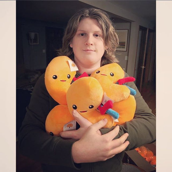 Teenage Boy holding three Nerdbugs Kidney Organ Plushies