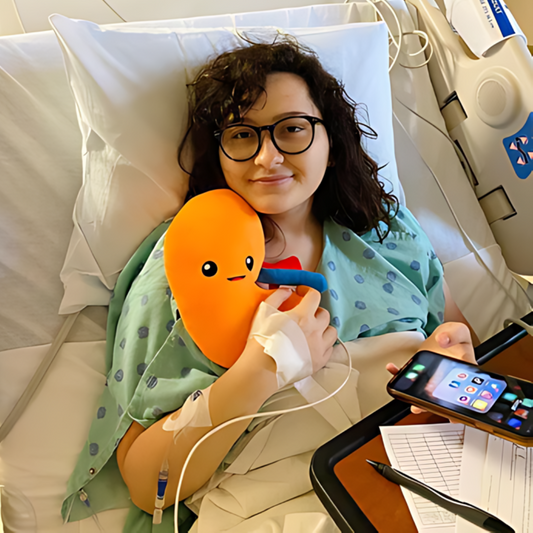 Lady on a hospital bed holding a Nerdbugs Kidney Plushie Organ