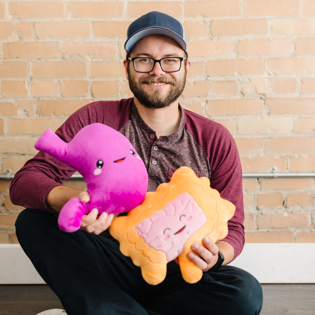 man holding nerdbugs stomach and intestine organ plushies