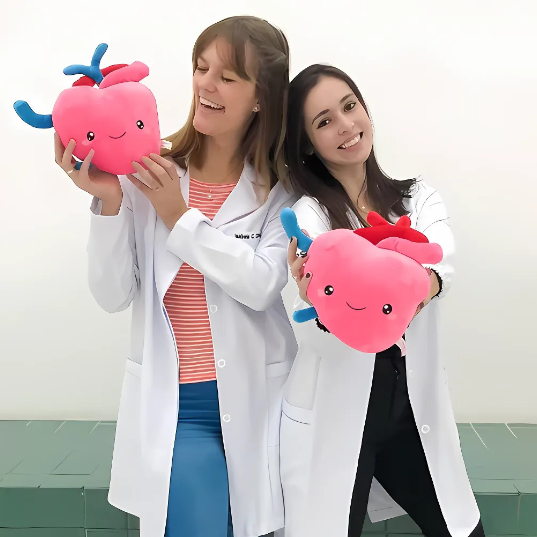 Two women in lab coats holding a heart plushies