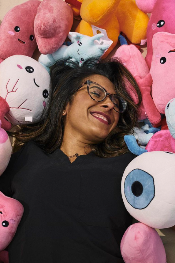 Nerdbugs CEO Ronak Mehta laying down on a pile of organ plushies