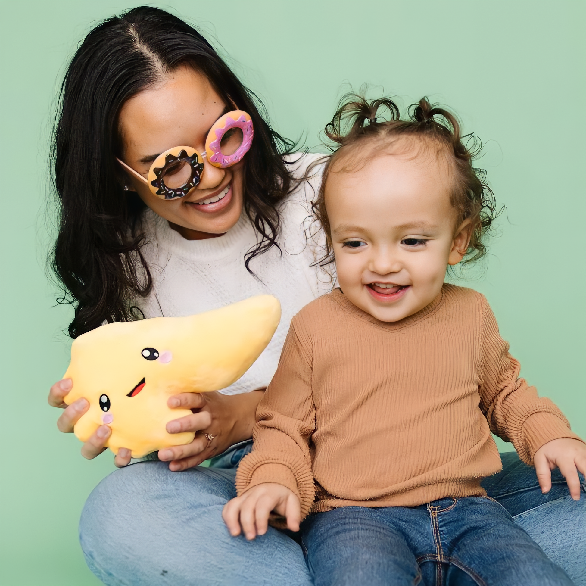 Mother and child in sky blue background holding a pancreas toy plushie