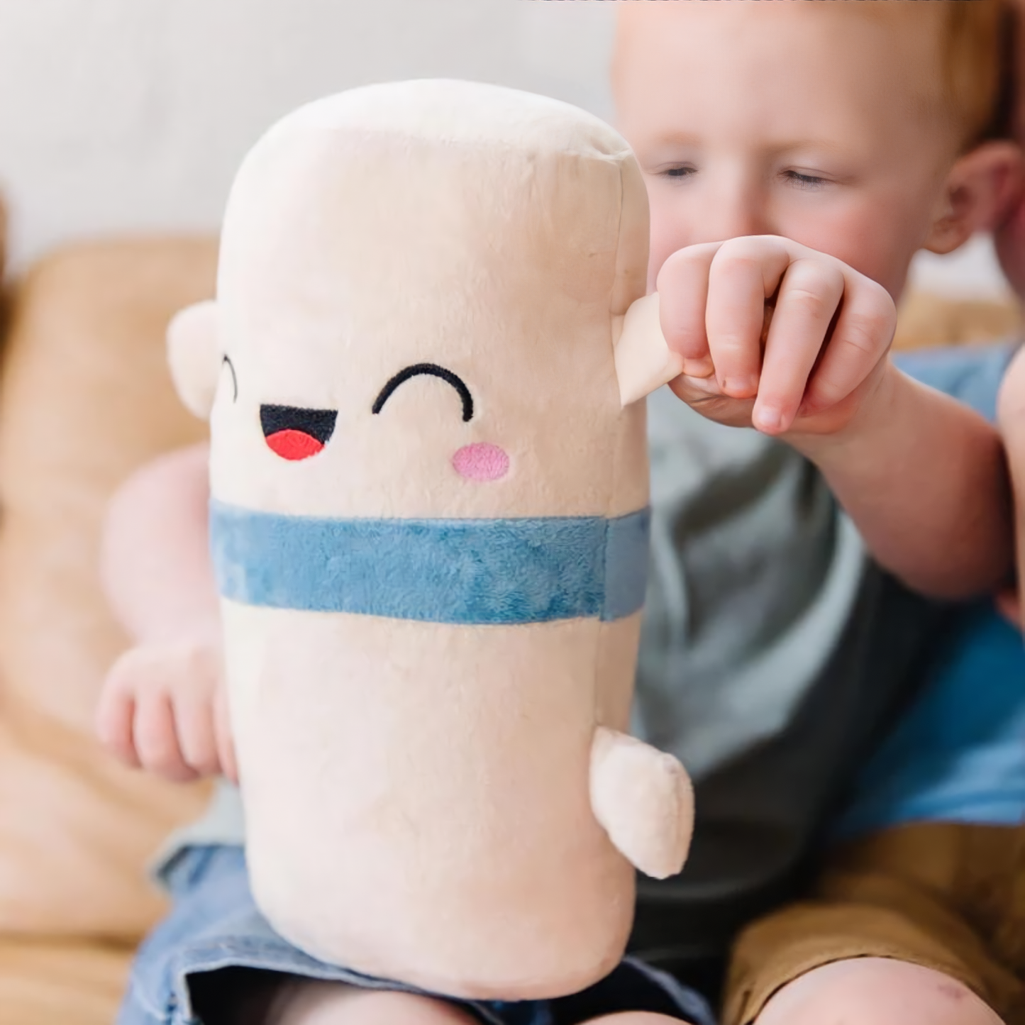 baby boy sitting holding a spine toy plushie